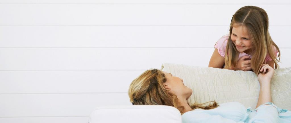 Mum lying on a lounge talking with daughter